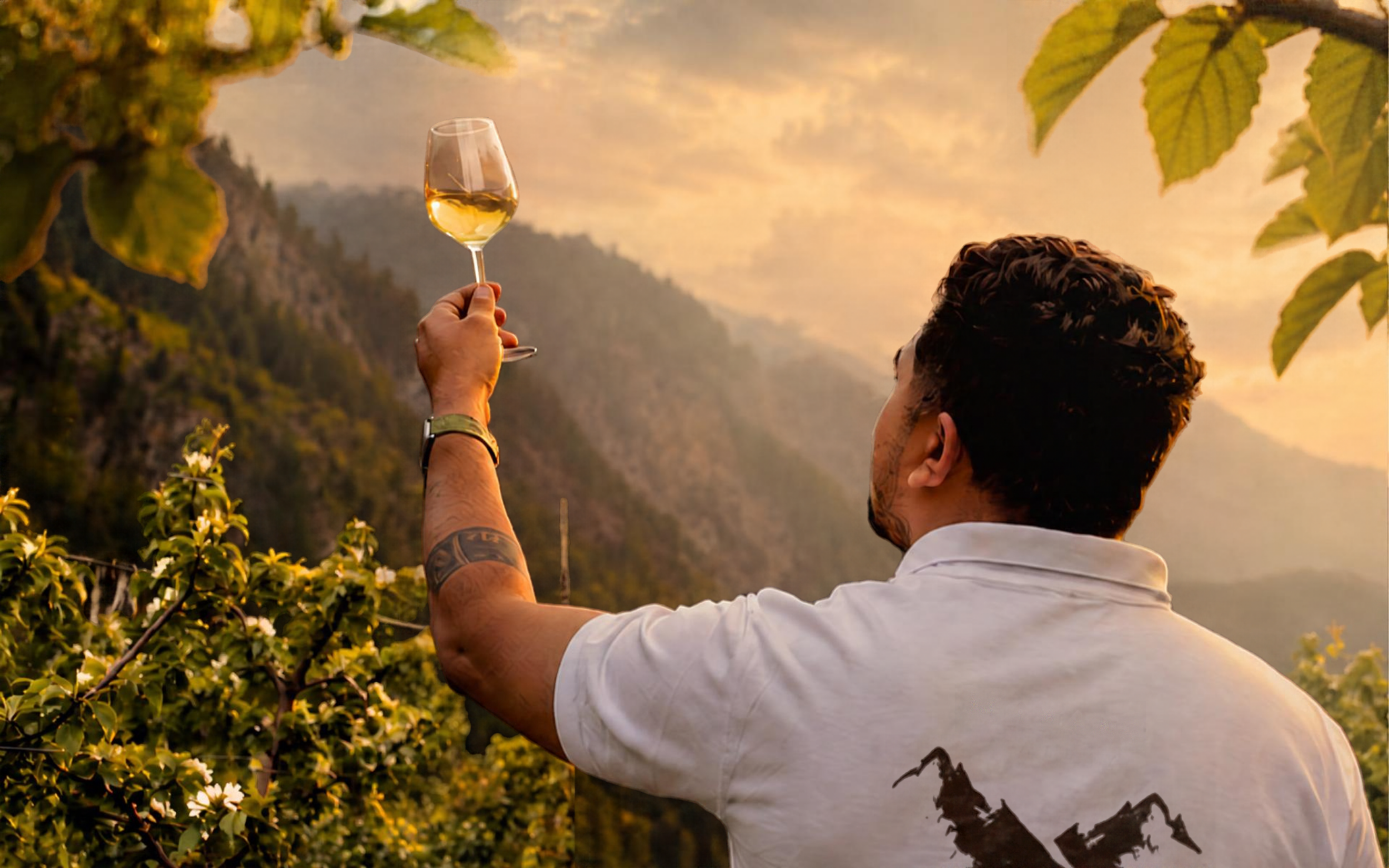 A man raises a glass of Manang Valley wine towards the mountains