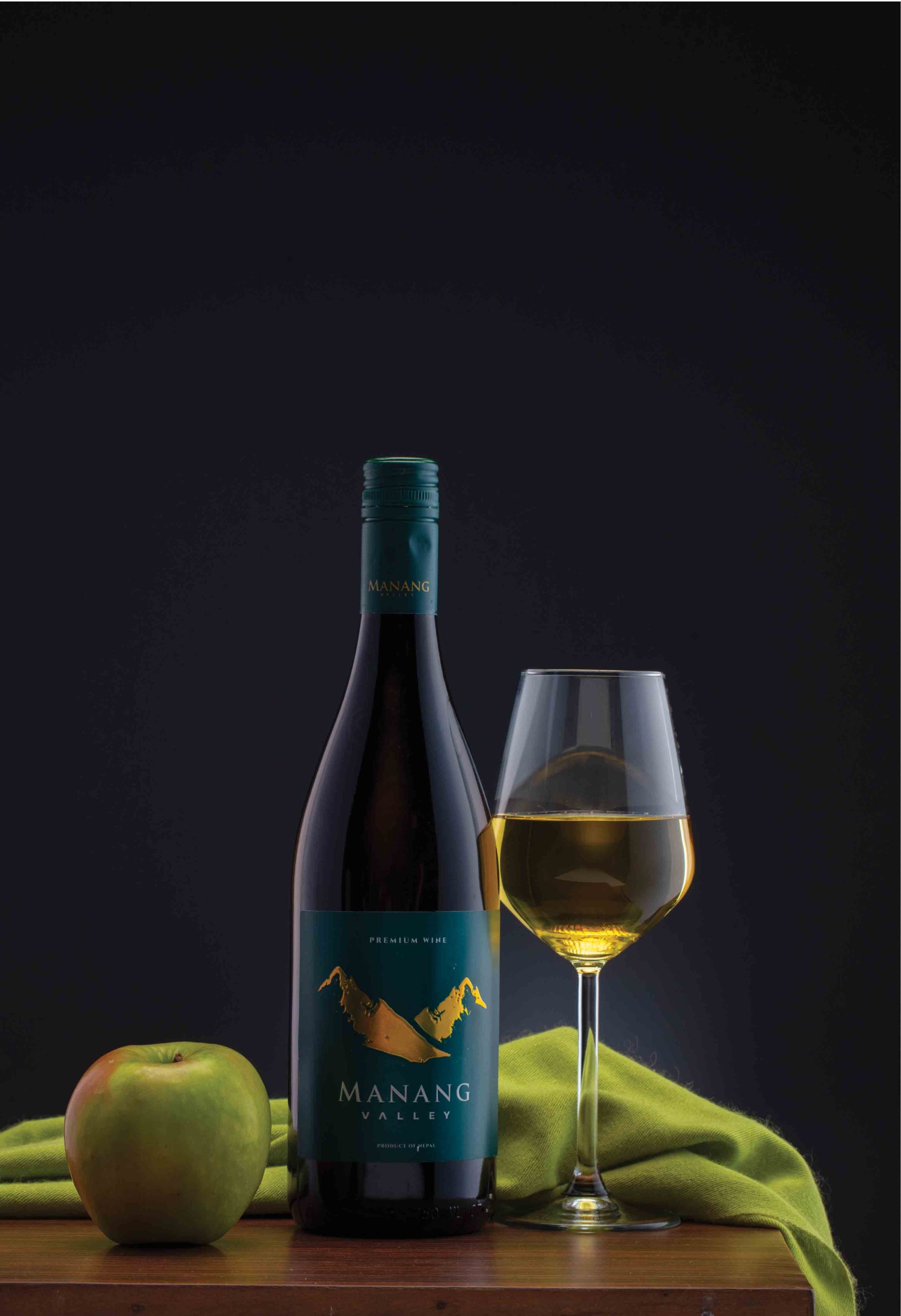 A beautiful picture of manang wine with a glass and a apple